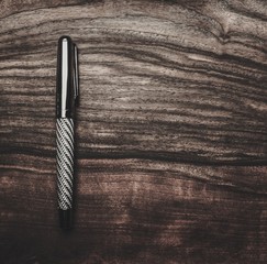 Luxurious rollerball pen on a wooden background