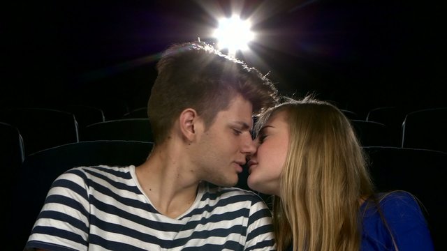 Stylish couple having romatic moment in a movie theater.  Close