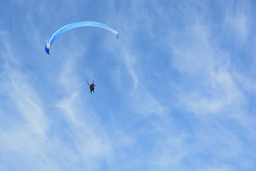 Naklejka na ściany i meble A paraglider gliding over sky