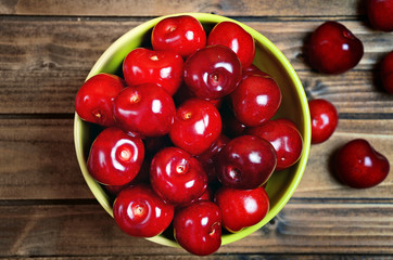 Bowl with cherries on wooden table