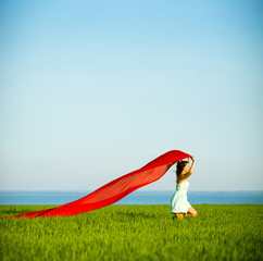 Young happy woman in wheat field with fabric. Summer lifestyle