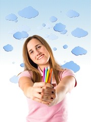 Blonde girl holding crayons over white background
