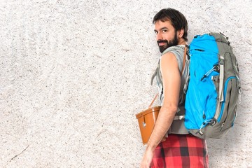 Young backpacker walking over white background