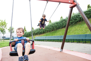 two children playing in the swing