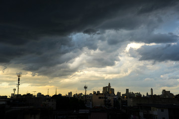 Naklejka premium Dark blue storm clouds over city in rainy season