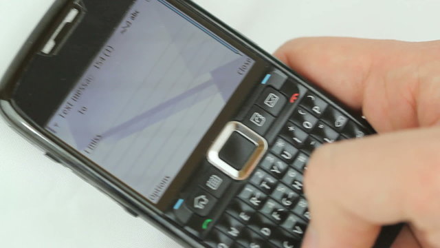 Texting a love message - Male hand typing a text message "I miss you soo much call me" on a smart phone with full qwerty keyboard