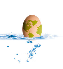 Egg with world map drop in blue water with shallow depth of field