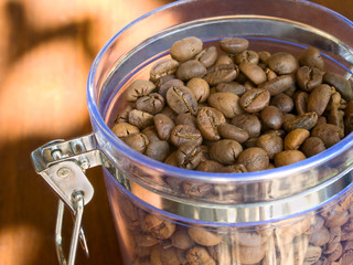 Appetizing coffee beans in glass container.