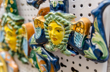 Souvenirs of the Trinacria symbol of Sicily and typical Sicilian glazed ceramic
