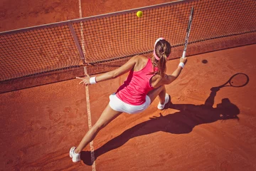 Fotobehang Young woman playing tennis.High angle view.Forehand volley. © BalanceFormCreative