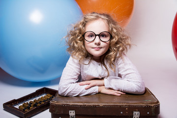 Teen girl in glasses with wooden abacus on the background of lar