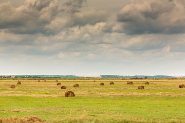 Landscape with bale of straw blue sky and clouds