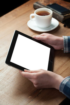 woman finger presses on screen digital tablet on wooden background. Shallow depth of field