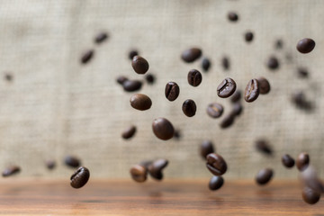 Coffee beans falling down on a wooden plank