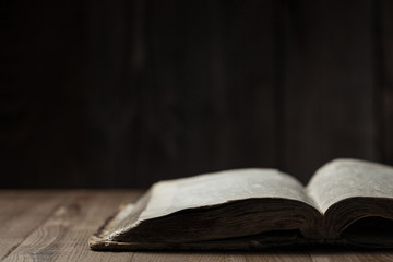 Image of a book on wooden background in a dark space