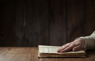 woman reading the bible in the darkness over wooden table