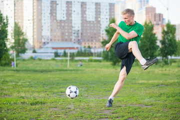 Soccer player strongly hits the ball.