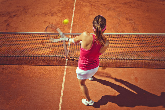 Young woman playing tennis.High angle view.Backhand volley.