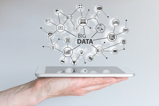 Big data and mobile computing concept. Hand holding silver tablet or smart phone