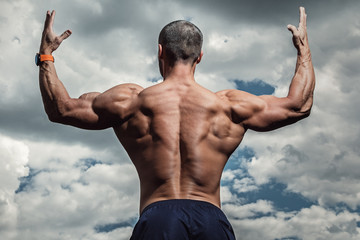 Muscular man under cloudy sky