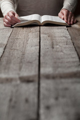 woman reading the bible in the darkness over wooden table © 4Max