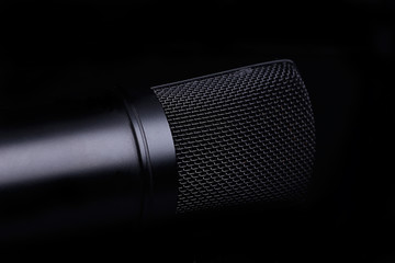 Black microphone on the black background