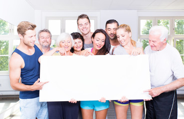 Sportgruppe zeigt auf Banner 