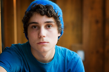teen boy wearing a hat and looking serious