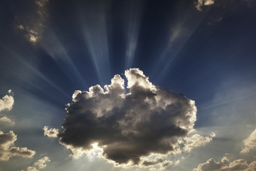 Slouds and sunbeams. Sun rays. Sunbeams going out from beahind the clouds