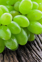 bunch of ripe and juicy green grapes  on the wooden table