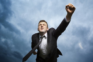 Crazy young man throws himself in front of him to attack. I want to catch something. He is furious and determined to reach your goal.