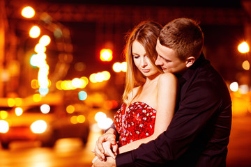 Handsome young man embracing beautiful woman in red dress