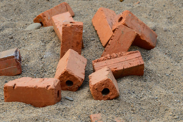 Red raw brick on sand for building instruction.