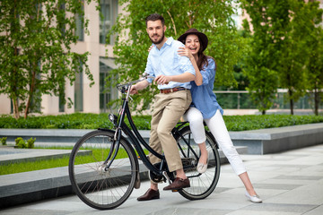 Young couple sitting on a bicycle 