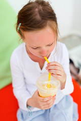 Little girl drinking smoothies outdoors