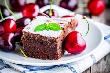 a piece of homemade chocolate brownie dessert with a cherry