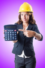 Female builder with calculator against the gradient
