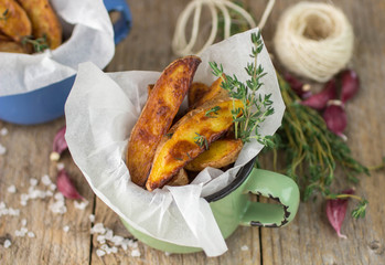 Potato wedges with thyme and garlic. The rustic style. Selective