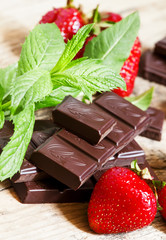 Delicious milk chocolate with strawberries and mint, selective f