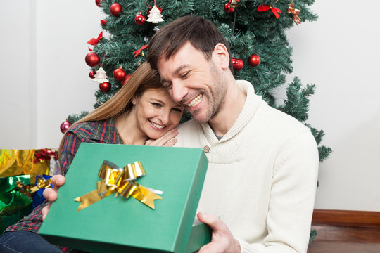 Fun Couple Opening A Christmas Gift