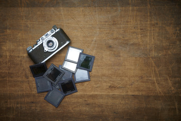 Vintage photo camera with reversal film photo frame on a wooden table