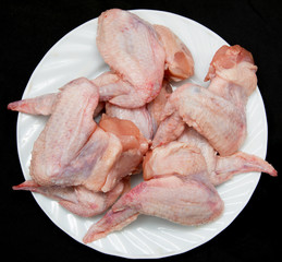 Fresh chicken wings on a black background