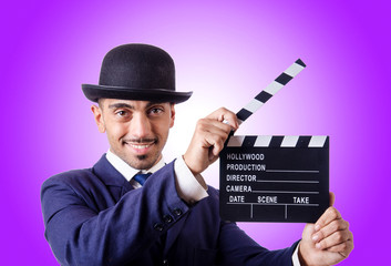 Man with movie clapper against the gradient 