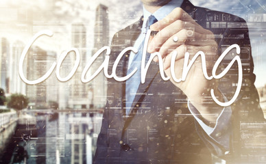 the businessman is writing Coaching on the transparent board with some diagrams and infocharts with...