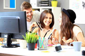 Group of three cheerful business partners looking at camera