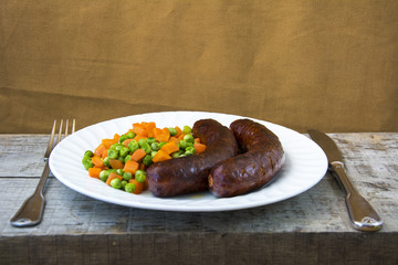 Sausages with vegetables on a white plate 