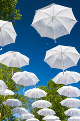Fototapeta na wymiar White umbrellas canes in the sky