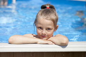 Fototapeta na wymiar Child girl in blue bikini near swimming pool. Hot Summer