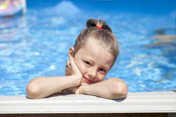 Child girl in blue bikini near swimming pool. Hot Summer