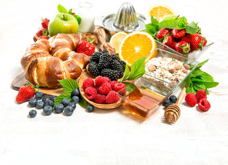 Healthy breakfast with croissants, muesli, fresh berries, fruits